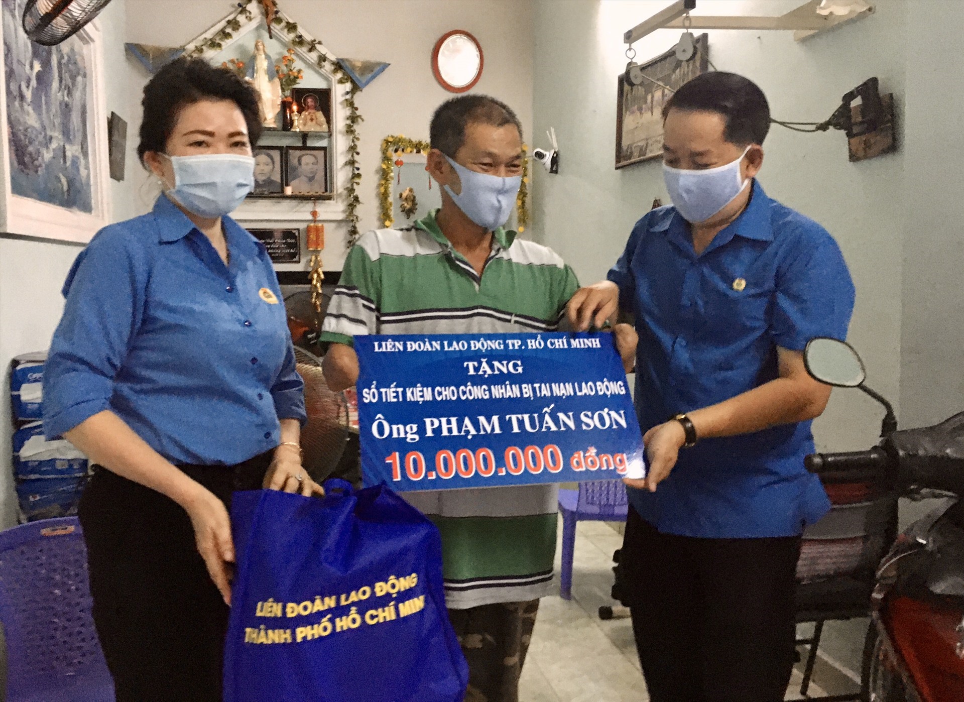 Ngày 27.4, Phó Chủ tịch LĐLĐ TPHCM Kiều Ngọc Vũ trao tặng sổ tiết kiệm và quà cho anh Phạm Tuấn Sơn bị tai nạn thương tật 88%. Ảnh Anh Tú.