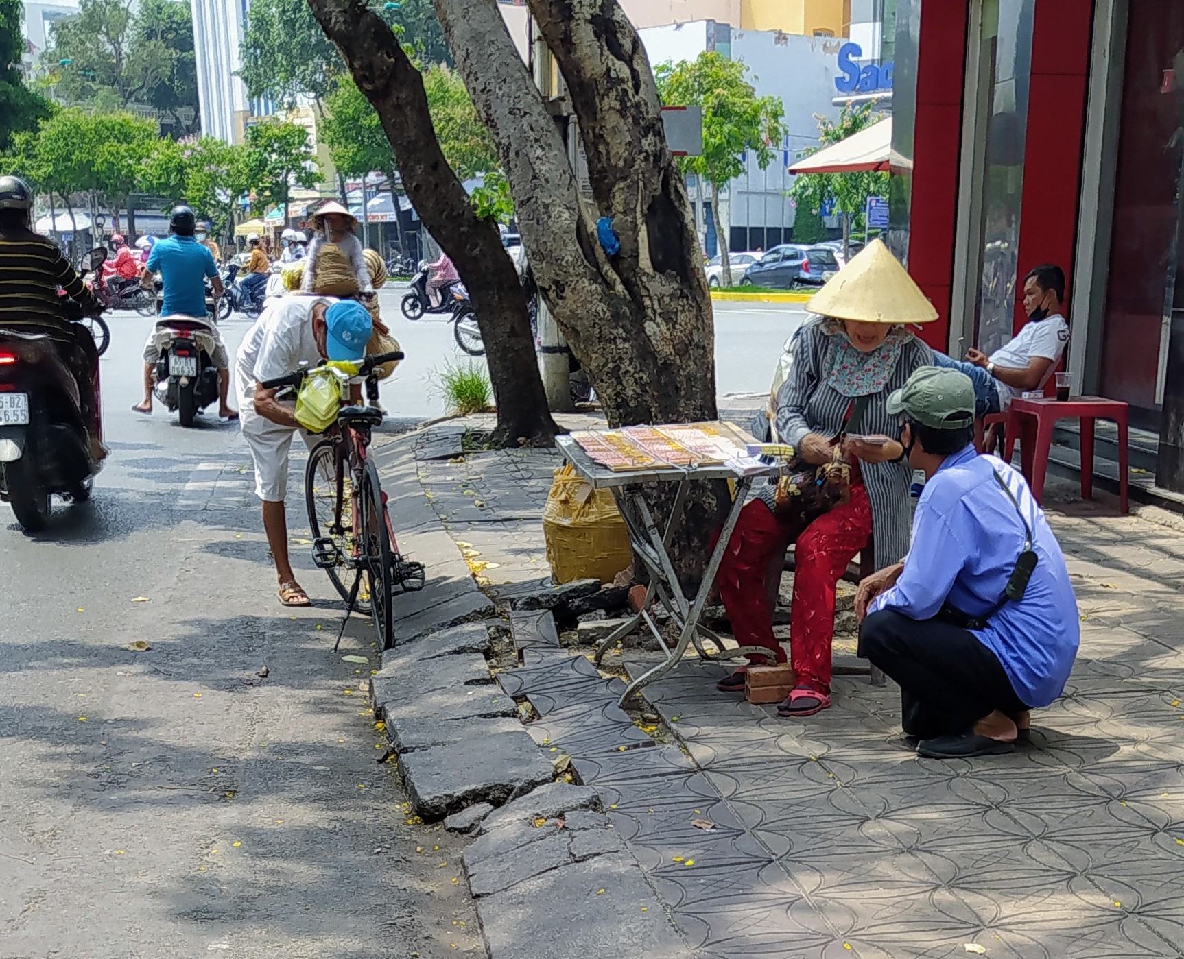 Trong sáng 28.4, lượng vé số bán ra ở Cần Thơ tiêu thụ mạnh. Trong ảnh: Một người bán dạo đang ngồi chờ “chia” lại vé số từ một sạp vé số để mang đi bán tiếp. Ảnh: Trần Lưu.