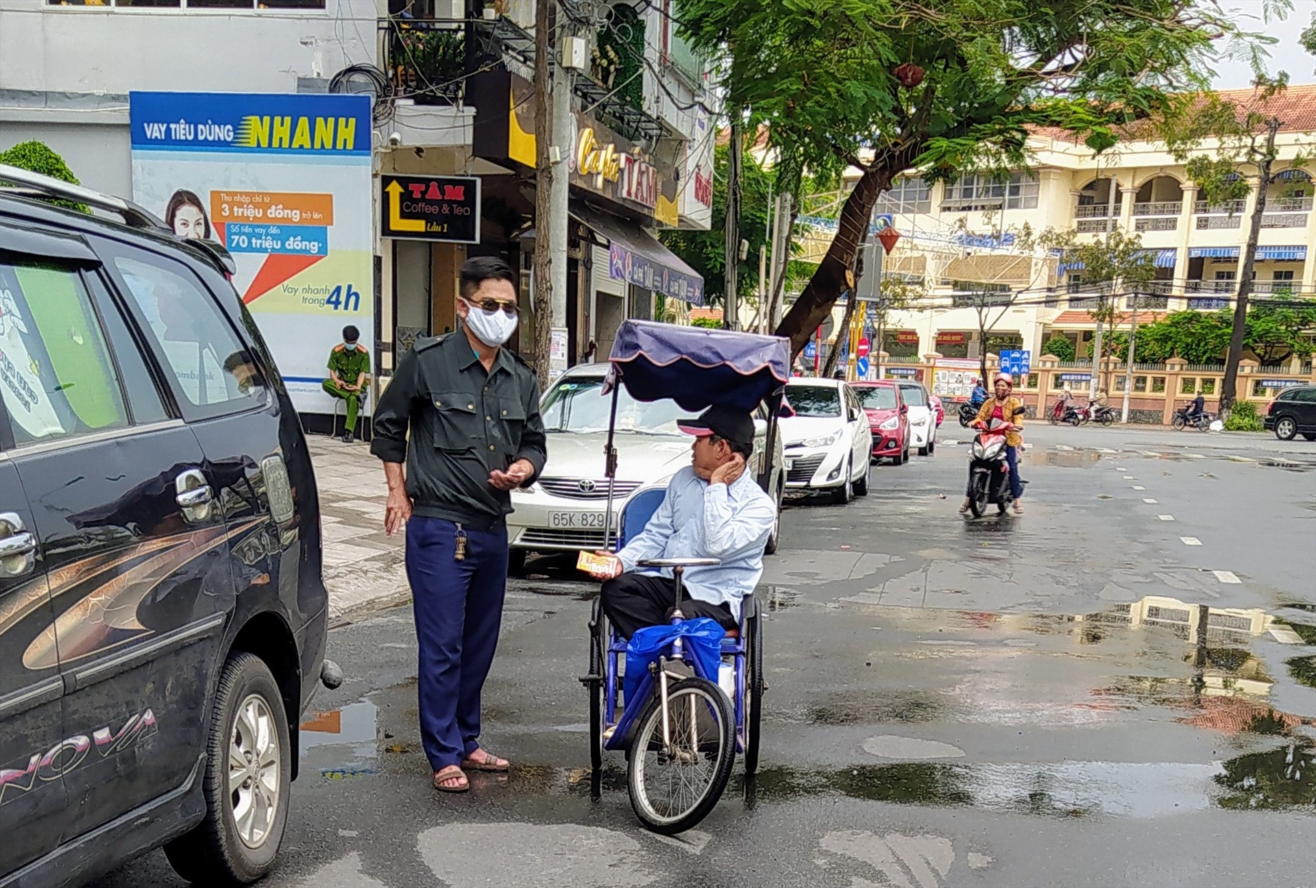 Một người dân mua vé số giúp một người khuyết tật bán dạo. Ảnh chụp trên tuyến đường Võ Văn Tần (quận Ninh Kiều, TP.Cần Thơ) vào trưa ngày 28.4. Ảnh: Tr.L
