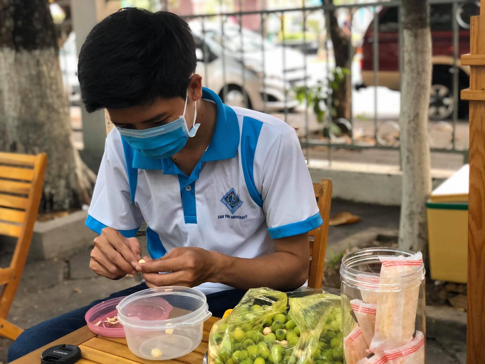 Anh Nguyễn Thành Giang - chủ xe sữa sen tranh thủ lột hạt sen lúc vắng khách. Ảnh: SH