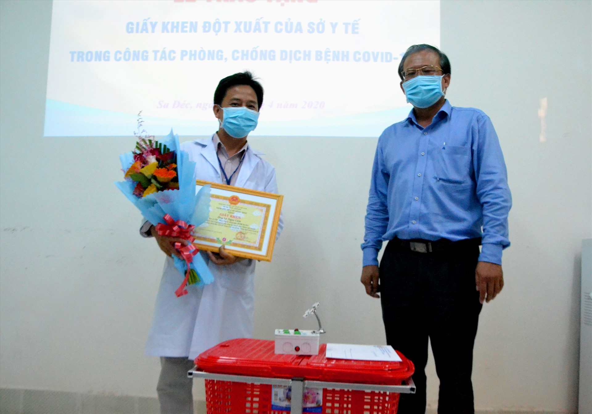 Giám đốc Sở Y tế Đồng Tháp Nguyễn Lâm Thái Thuận (phải) tặng hoa, trao Giấy khen cho bác sĩ Lê Ngọc Lâm. Ảnh: LT