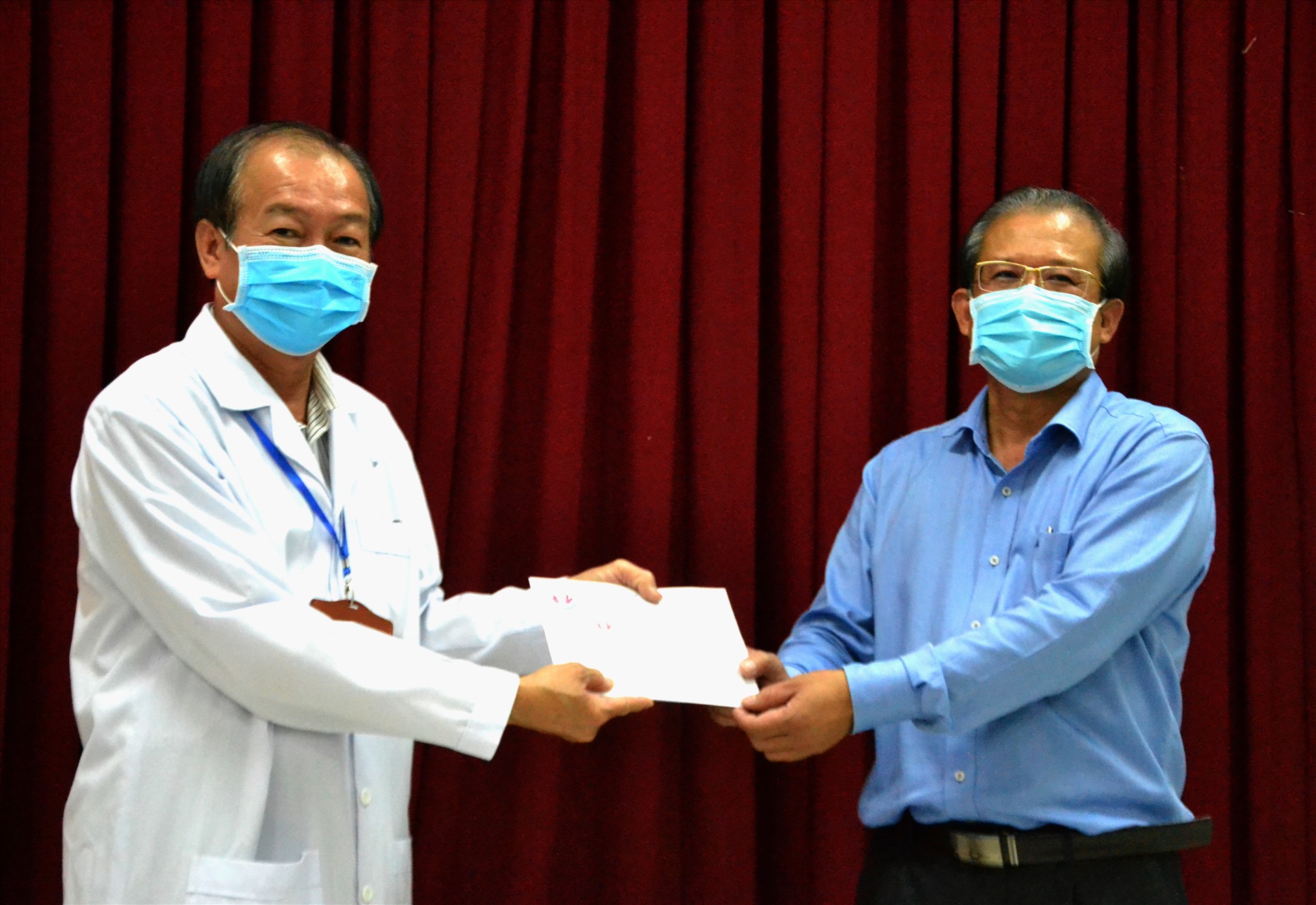 Bác sĩ Nguyễn Lâm Thái Thuận  (phải) trao thưởng cho e kíp thầy thuốc điều trị thành công 4 người dương tính với virus SARS-CoV-2. Ảnh: LT