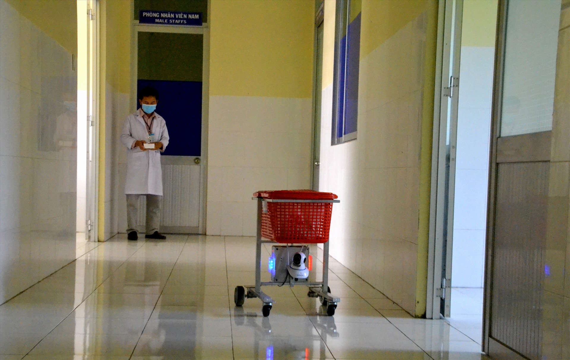 Thông qua điều khiển từ xa, điều hành robot mang vật dụng đến tận cửa phòng bệnh nhân. Ảnh: LT