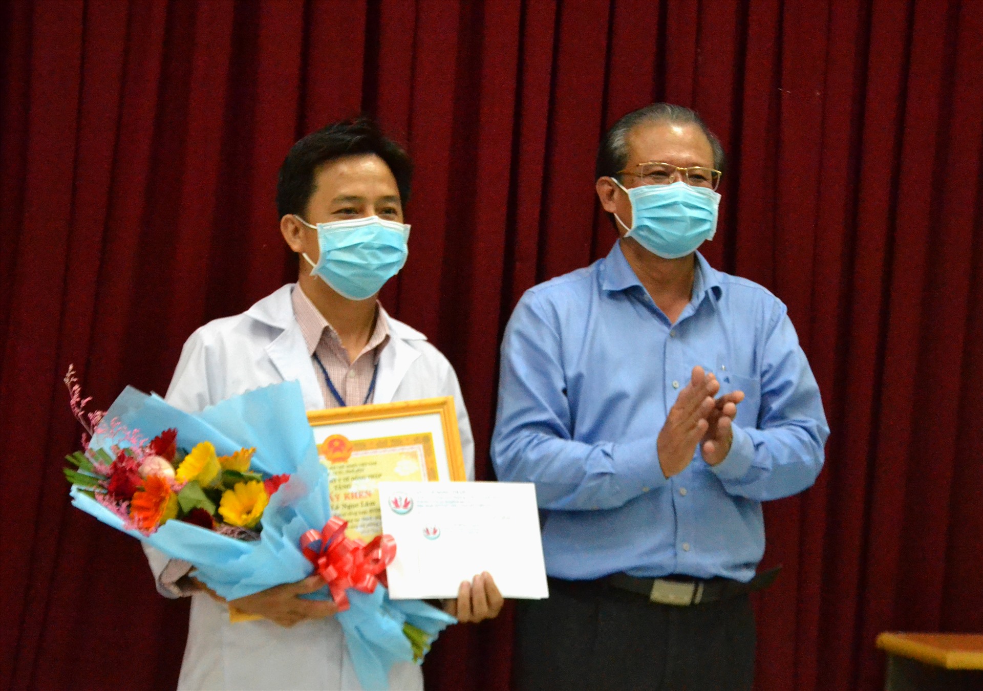 Bác sĩ Nguyễn Lâm Thái Thuận trao khen thưởng cho bác sĩ Lê Ngọc Lâm. Ảnh: LT