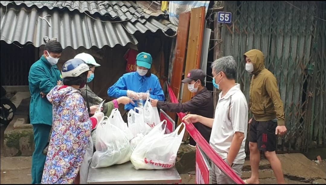 Các lực lượng chức năng phường Dịch Vọng và các đội tình nguyện viên chuyển các túi lương thực, vật dụng y tế đến trực tiếp người dân trong khu vực cách ly y tế. Ảnh: Phạm Đông