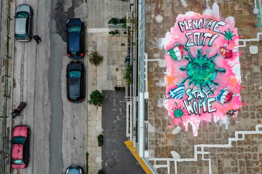 Nghệ sĩ 16 tuổi SF vẽ một bức tranh tường về cuộc khủng hoảng COVID-19 trên một mái nhà ở Athens, Hy Lạp. Ảnh: AFP/Getty Images.