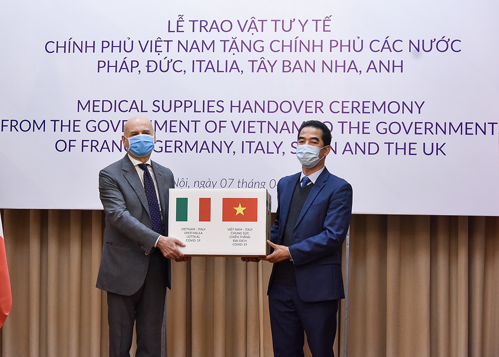 Thứ trưởng Tô Anh Dũng trao tượng trưng hàng hỗ trợ chống dịch COVID-19 cho Italia. Ảnh: BNG
