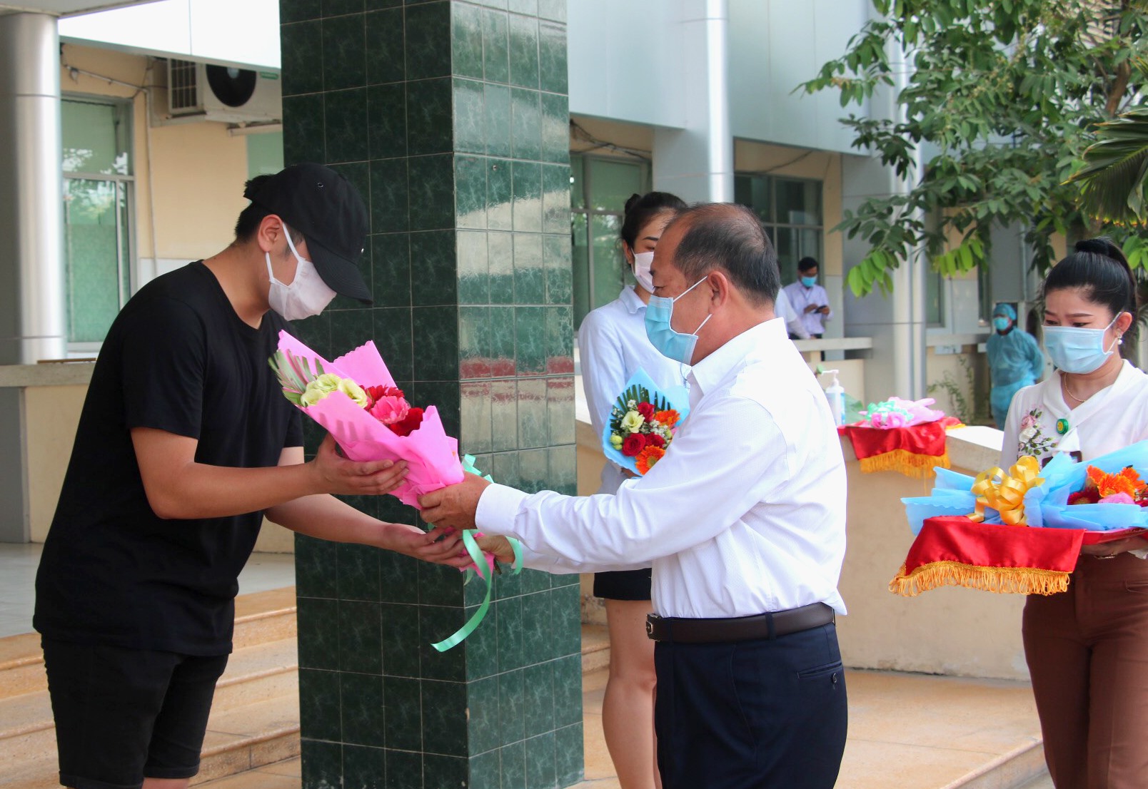 Phó Chủ tịch UBND tỉnh Đồng Tháp Đoàn Tấn Bửu tặng hoa cho các công dân nhận Giấy chứng nhận hoàn thành thời gian cách ly. Ảnh: LT