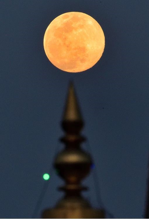 Siêu trăng lên ở tiền cảnh của một ngôi đền ở Gurugram, Ấn Độ. Ảnh: PTI.