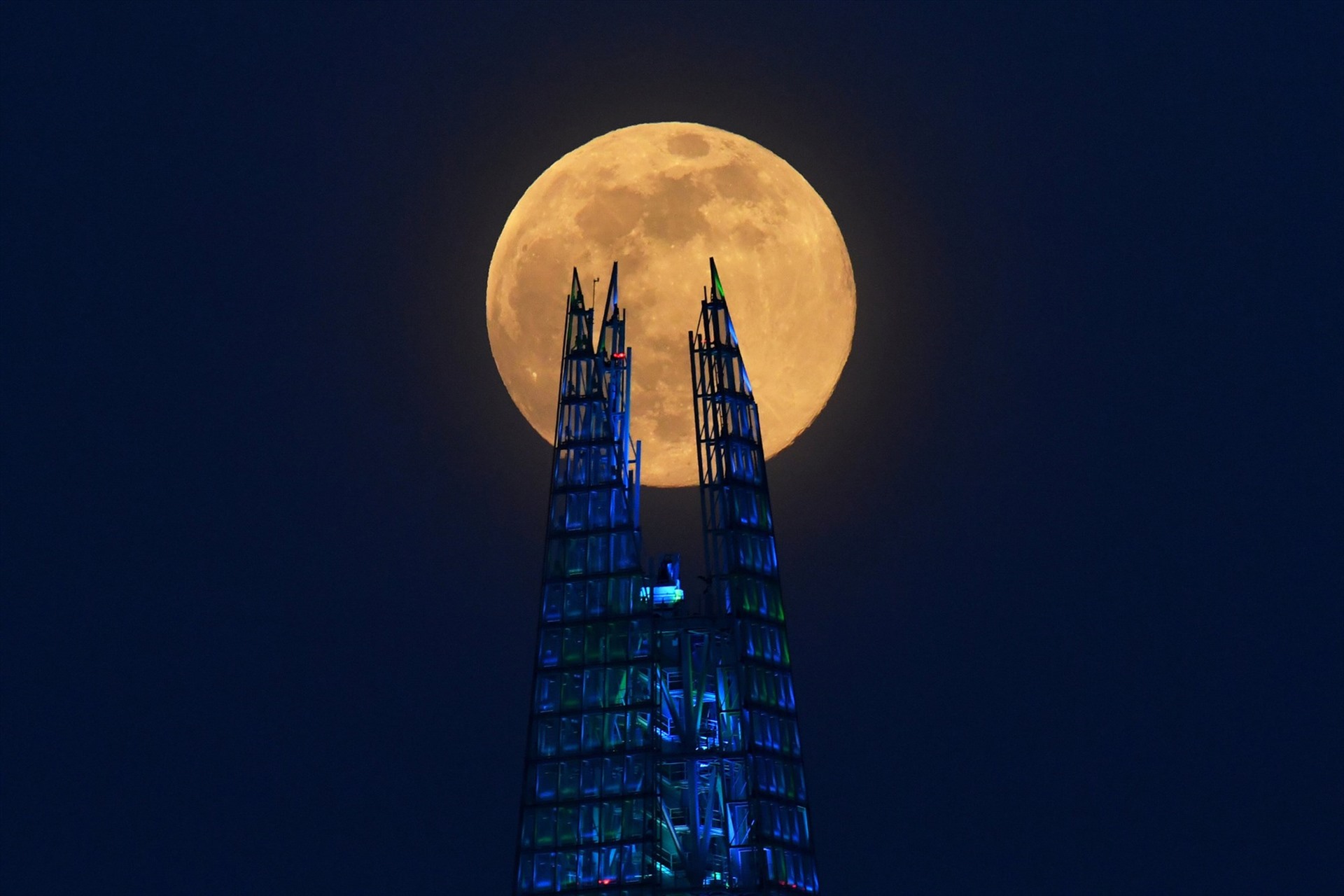 Siêu trăng hồng - siêu trăng lớn nhất và sáng nhất năm 2020 - được quan sát ở cao ốc Shard ở London, Anh tối 7.4. Ảnh: Reuters.