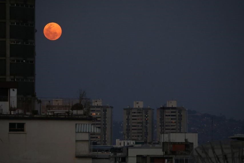 Siêu trăng hồng quan sát ở thành phố Caracas, Venezuela. Ảnh: Reuters.