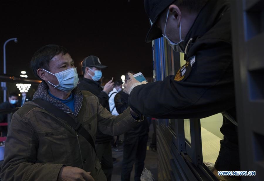 Hành khách Liu Xuất trình mã sức khỏe cho một nhân viên tàu hỏa trước khi vào ga xe lửa Vũ Xương ở Vũ Hán, tỉnh Hồ Bắc, Trung Quốc vào cuối ngày 7.4. Ảnh: Xinhua.