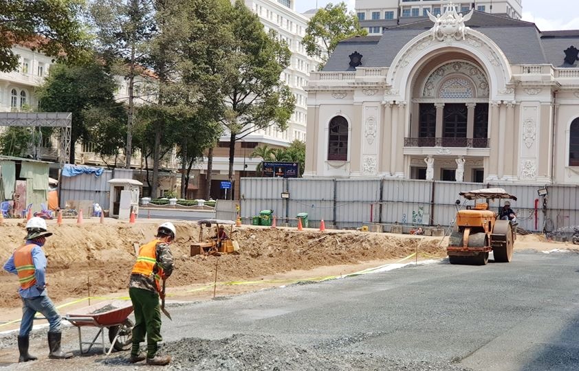 Công nhân tái lập mặt bằng tuyến metro số 1 để chuẩn bị cho việc tháo dỡ rào chắn phía trước Nhà hát Thành phố.  Ảnh: Minh Quân