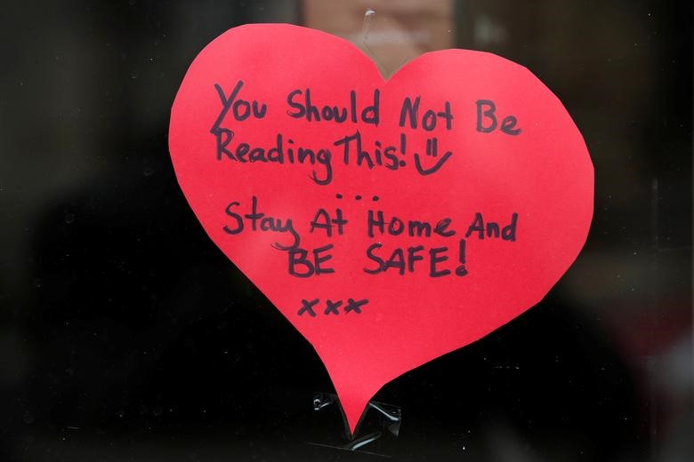 Một thông điệp được dán trên cửa kính của một cửa hàng tại Anh với nội dung: “Bạn không nên đọc những dòng này. Hãy ở nhà và giữ an toàn“. Ảnh: Reuters