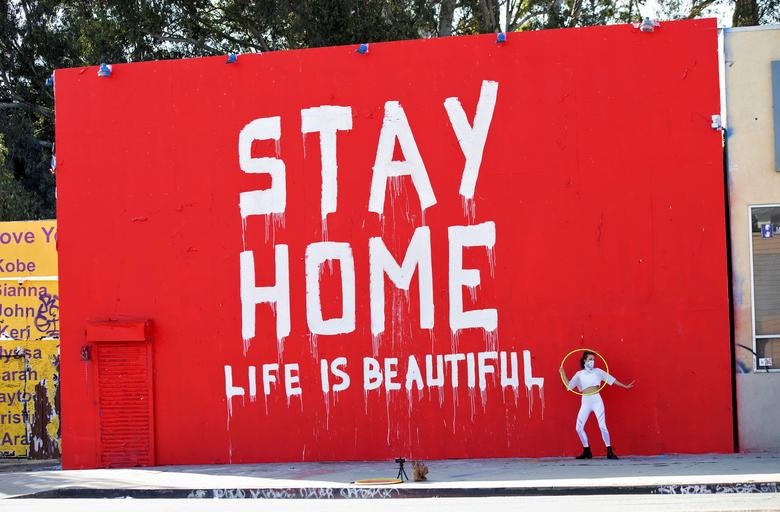 Huấn luyện viên khiêu vũ Morgan Jenkins tạo dáng trước bức tường ở Los Angeles, California với thông điệp: “Stay Home. Life is beautiful” (Hãy ở nhà. Cuộc sống thực sự rất tươi đẹp). Ảnh: Reuters