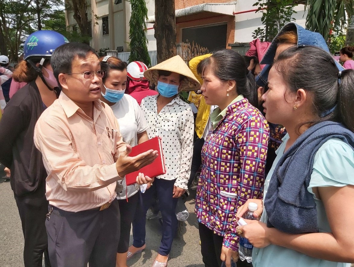 Ông Phạm Văn Hiền (bìa trái) Phó Chủ tịch CĐ các KCX&CN TPHCM giải thích các quy định của pháp luật với công nhân. Ảnh Nam Dương