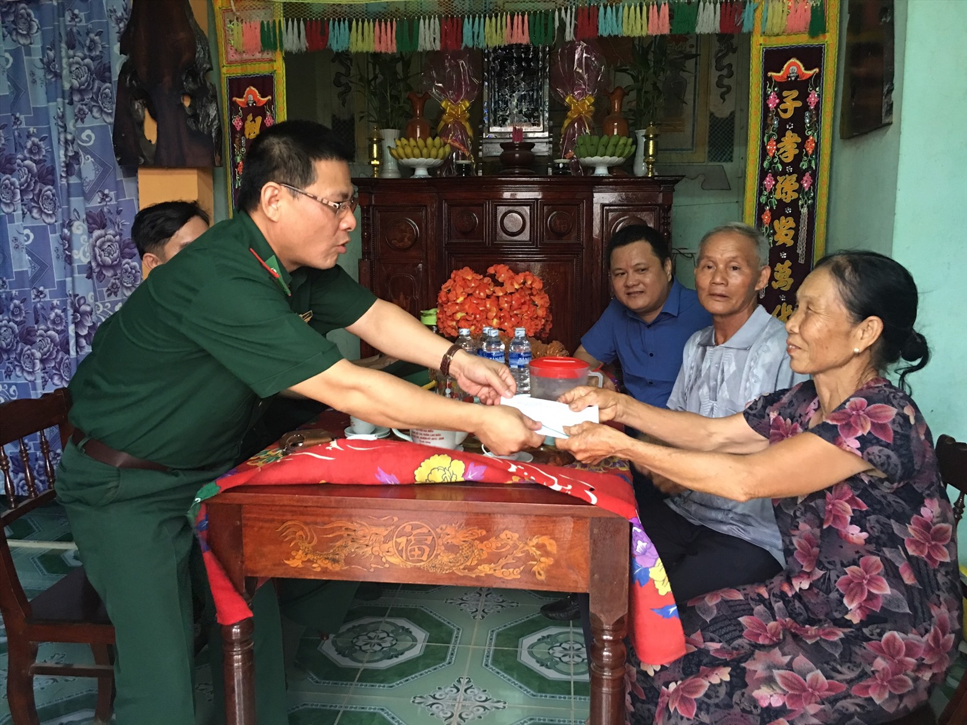Thượng tá Trần Tuấn Anh, Phó Chỉ huy trưởng BCH Biên phòng Quảng Trị trao quà cho gia đình bà Xưng. Ảnh: YMS.