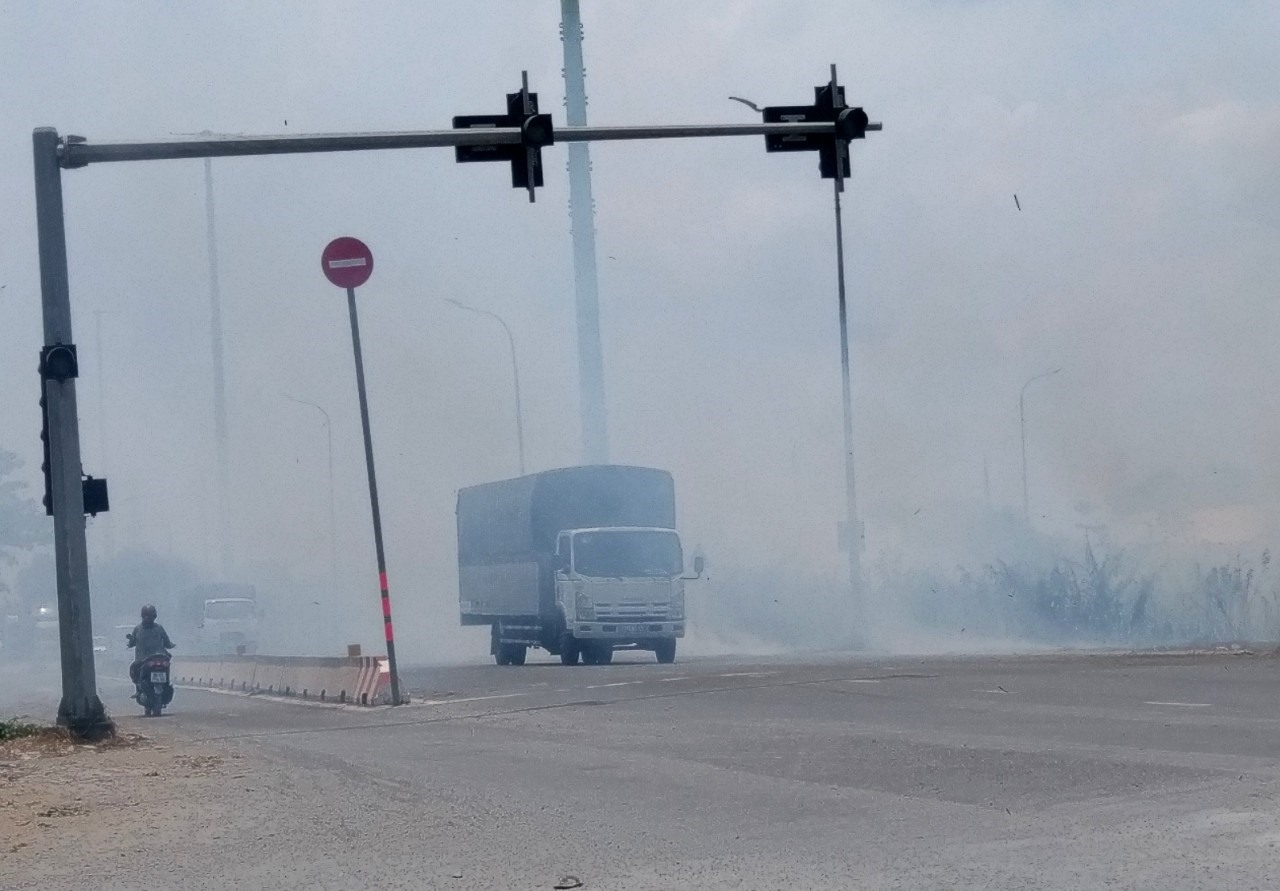 Đốt cỏ gây khói mù mịt trên đường Võ Chí Công trưa ngày 14.5.  Ảnh: Minh Quân