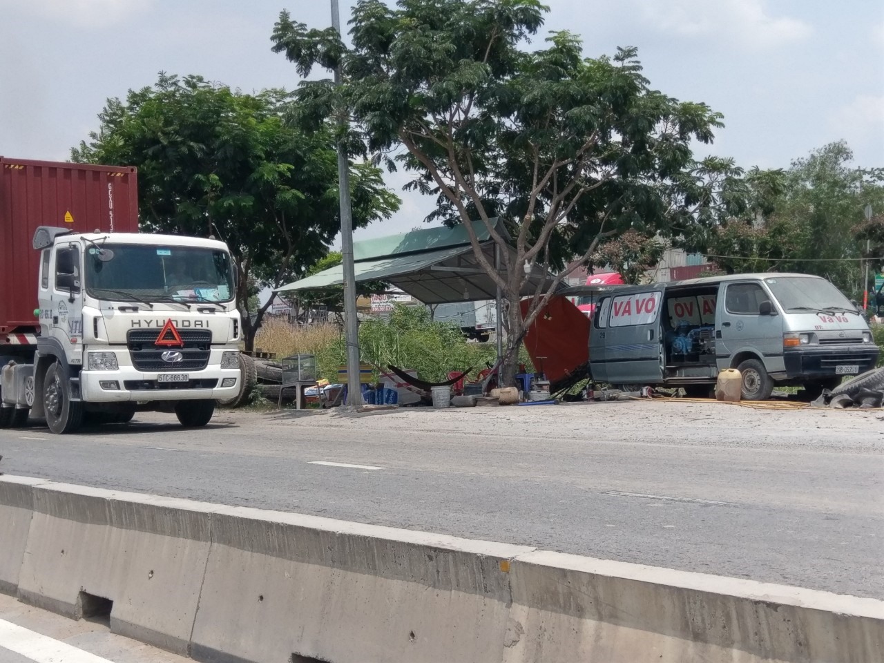 Dọc đường Võ Chí Công có rất nhiều điểm sửa xe tự phát khiến xe container đậu tràn lan. Ảnh: Minh Quân