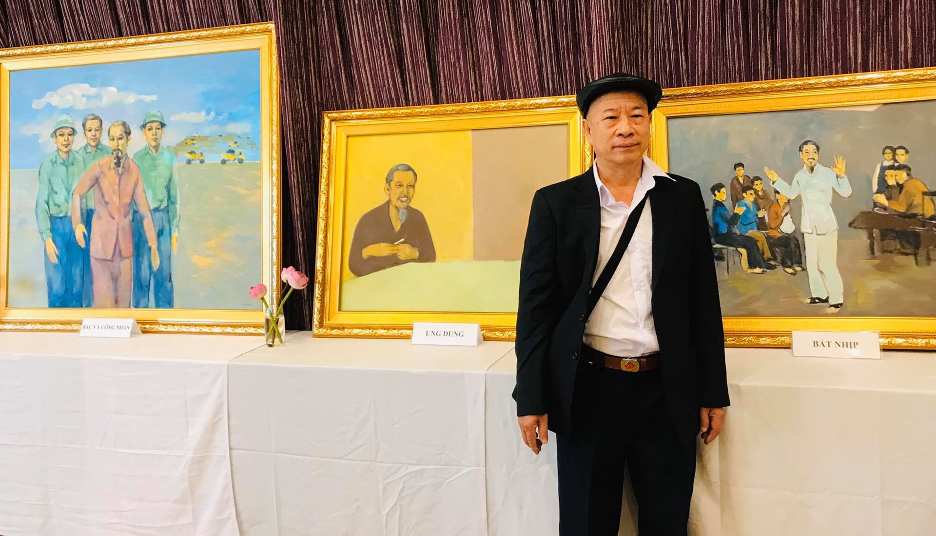Hoạ sĩ Thái Hoà bên những tác phẩm của mình tại triển lãm. Ảnh: Thuỳ Dương.