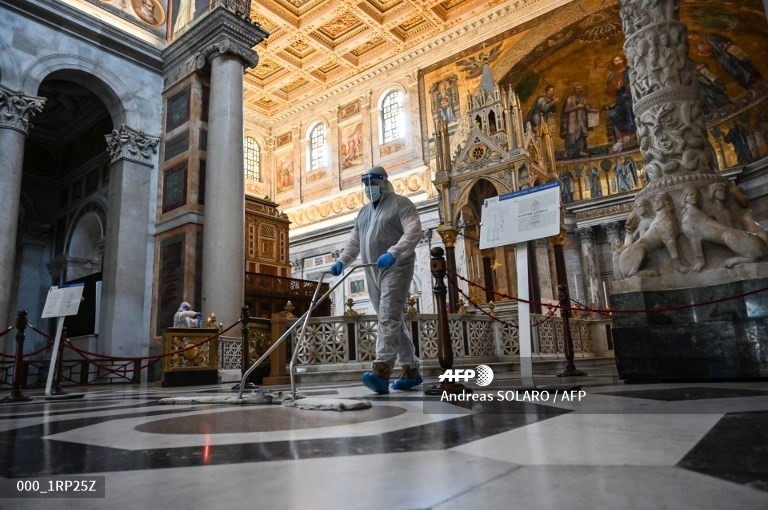 Một người đàn ông mặc đồ bảo hộ dọn dẹp Nhà thờ thánh Saint Paul bên ngoài Bức tường ở Rome, vào ngày 16.5. Ảnh: AFP
