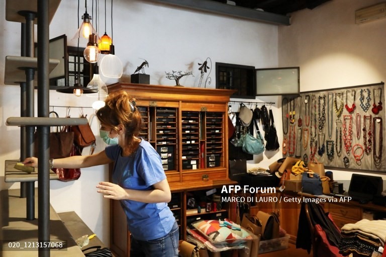 Nhân viên của cửa hàng Pandora della Malva sắp xếp, dọn dẹp cửa hàng hôm 15.5. Ảnh: AFP