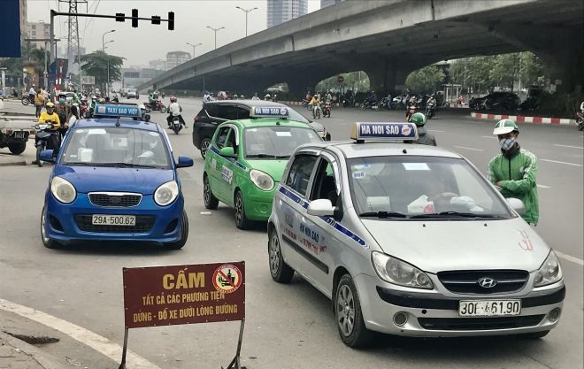 Nhiều taxi, xe ôm công nghệ vi phạm về dừng đỗ trước cửa bến xe Mỹ Đình. Ảnh: Minh Hải – Duy Hoàng