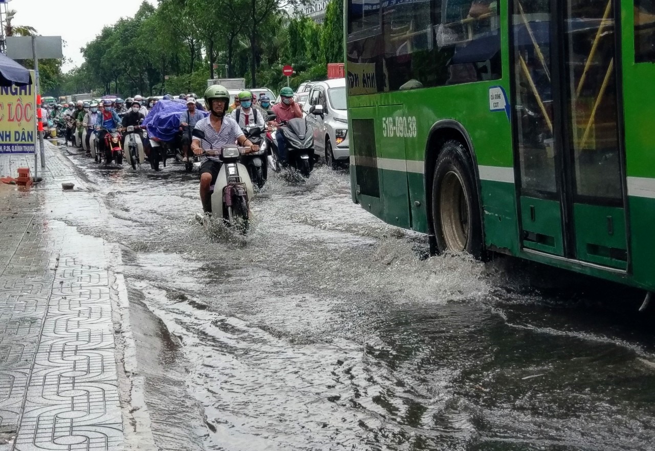Tại đường Định Bộ Lĩnh (quận Bình Thạnh) đoạn giao với đường Nguyễn Xí nước ngập kéo dài hơn 200m khiến giao thông hỗn loạn.  Ảnh: Minh Quân