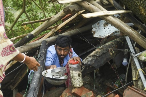 Dân làng  thu dọn  đồ đạc còn sót lại trong đống đổ nát do bị thiệt hại siêu bão ở Midnapore, Tây Bengal, Ấn Độ, ngày 21.5. Ảnh: AFP