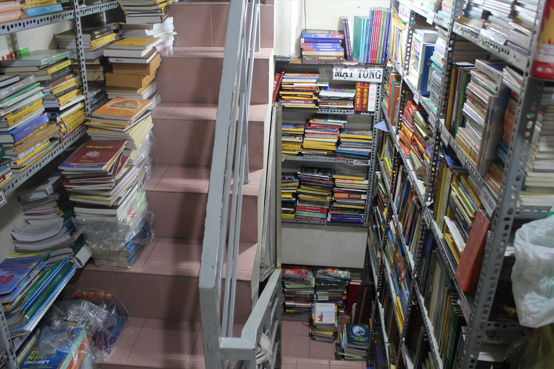 Do tiệm sách khá chật chội, số lượng đầu sách không ngừng tăng lên nên ông Cần phải tận dụng cả những lối đi ở cầu thang để đặt sách. Ảnh: Chân Phúc