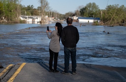Cư dân khu vực Sanford, Michigan đang đứng quan sát nước lũ ngày 21.5. Thống đốc Gretchen Whitmer đã tuyên bố tình trạng khẩn cấp ở Hạt Midland, nơi có các con đập bị vỡ gây ra lũ lụt. Ảnh: AFP