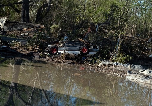 Một chiếc ô tô bị lũ cuốn trôi mắc lại trên bờ sông ở Sanford, Michigan,  21.5. Ảnh: AFP.