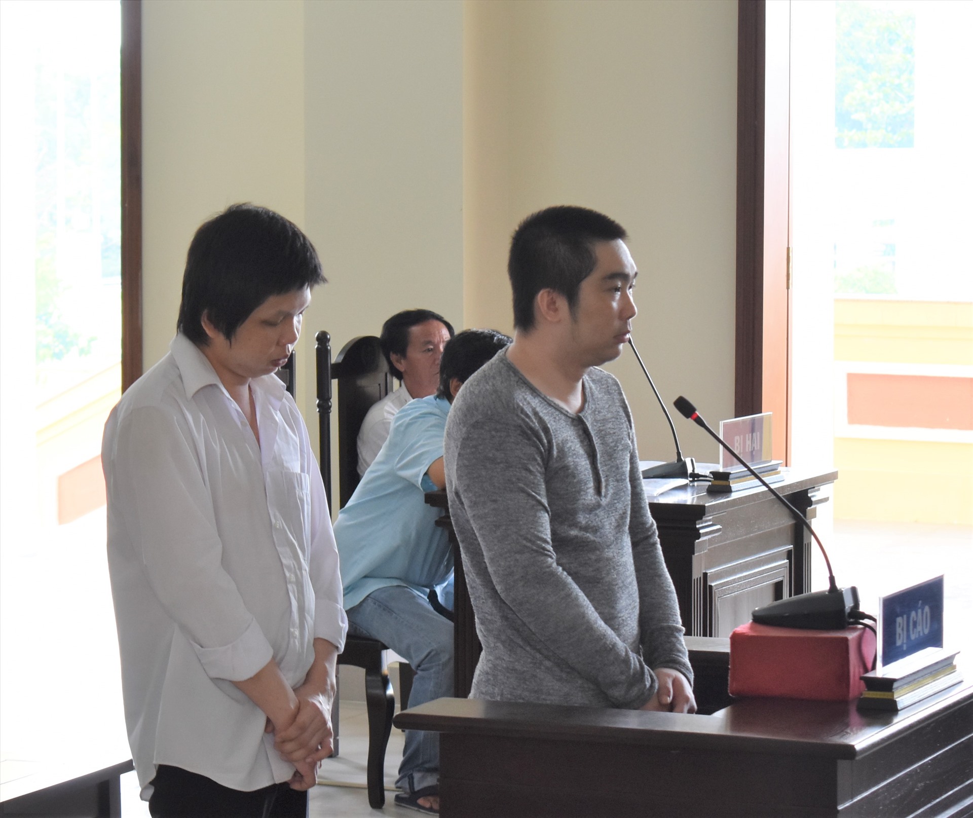2 bị cáo Trương Tấn Phát (áo trắng) và Bùi Thế Tín (áo xám) tại phiên tòa sơ thẩm. Ảnh: Thành Nhân