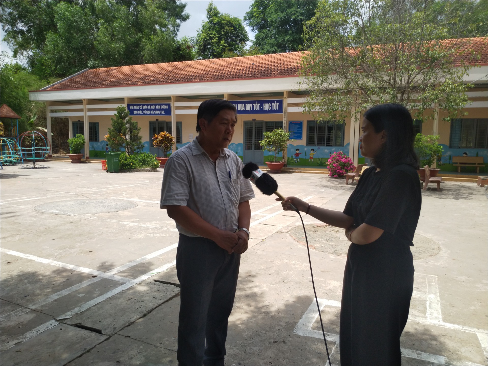 Thầy hiệu trưởng Lê Văn Hải trả lời báo chí tại sân trường TH-THCS Lộc Giang, điểm trưởng Ao Vuông. Ảnh: K.Q