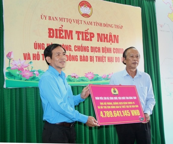 Đồng chí Trần Hoàng Vũ (bên trái) trao bảng tượng trưng hơn 4,7 tỷ đồng đóng góp cho Quỹ phòng, chống dịch bệnh COVID-19 và hỗ trợ đồng bào thiệt hại do hạn hán. Ảnh: Hùng Lưu