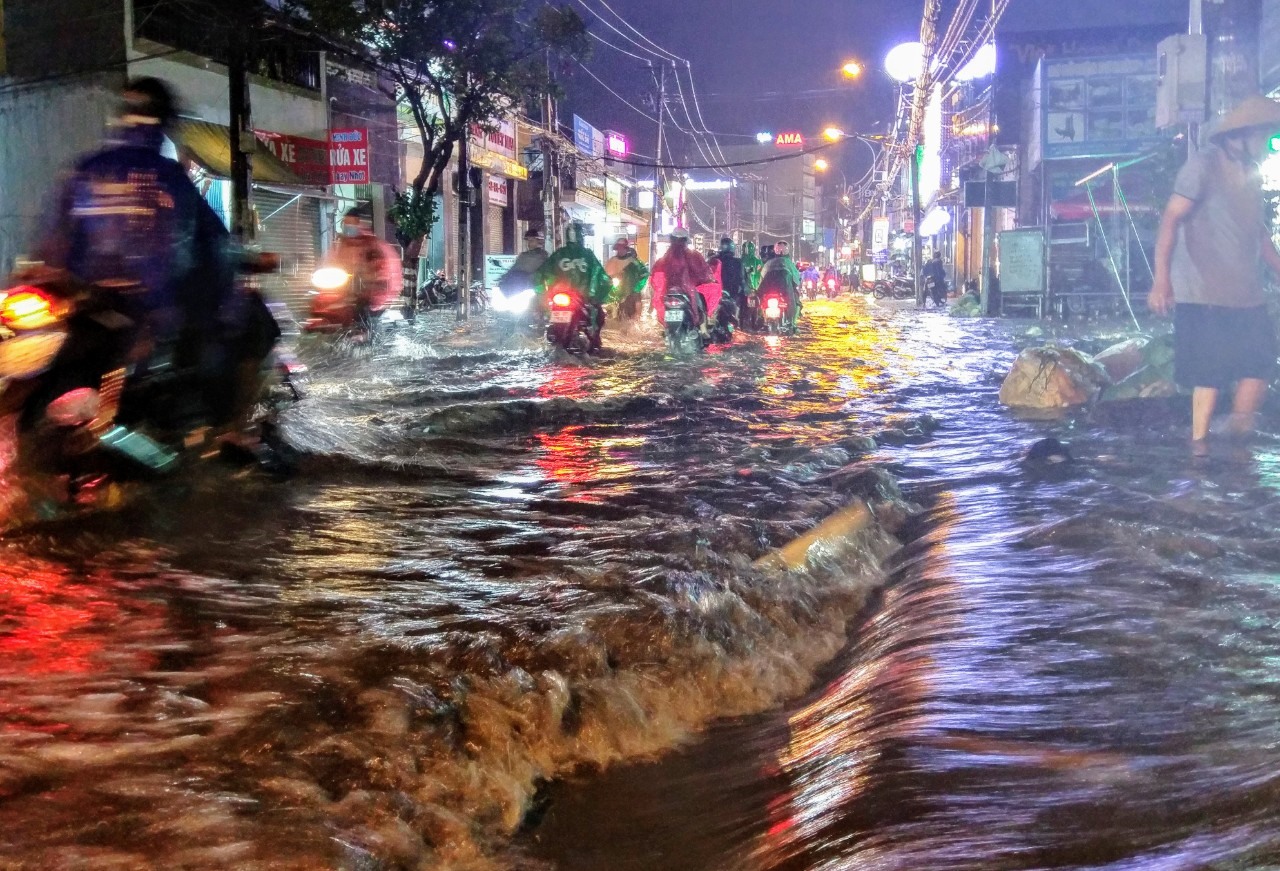 Sau mưa lớn, cuồn cuộn xuống đường Tô Ngọc Vân do suối khu vực này bị tắc nghẽn bởi rác thải.  Ảnh: Minh Quân