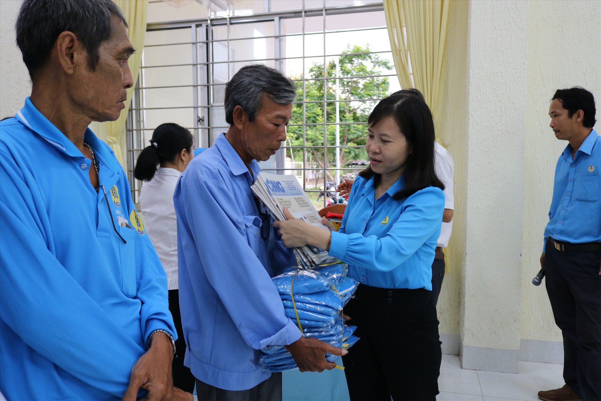 Chủ tịch LĐLĐ huyện Cao Lãnh Phạm Thị Xuân Mai trao tặng đồng phục và Báo Lao động cho đoàn viên nghiệp đoàn. Ảnh: HL
