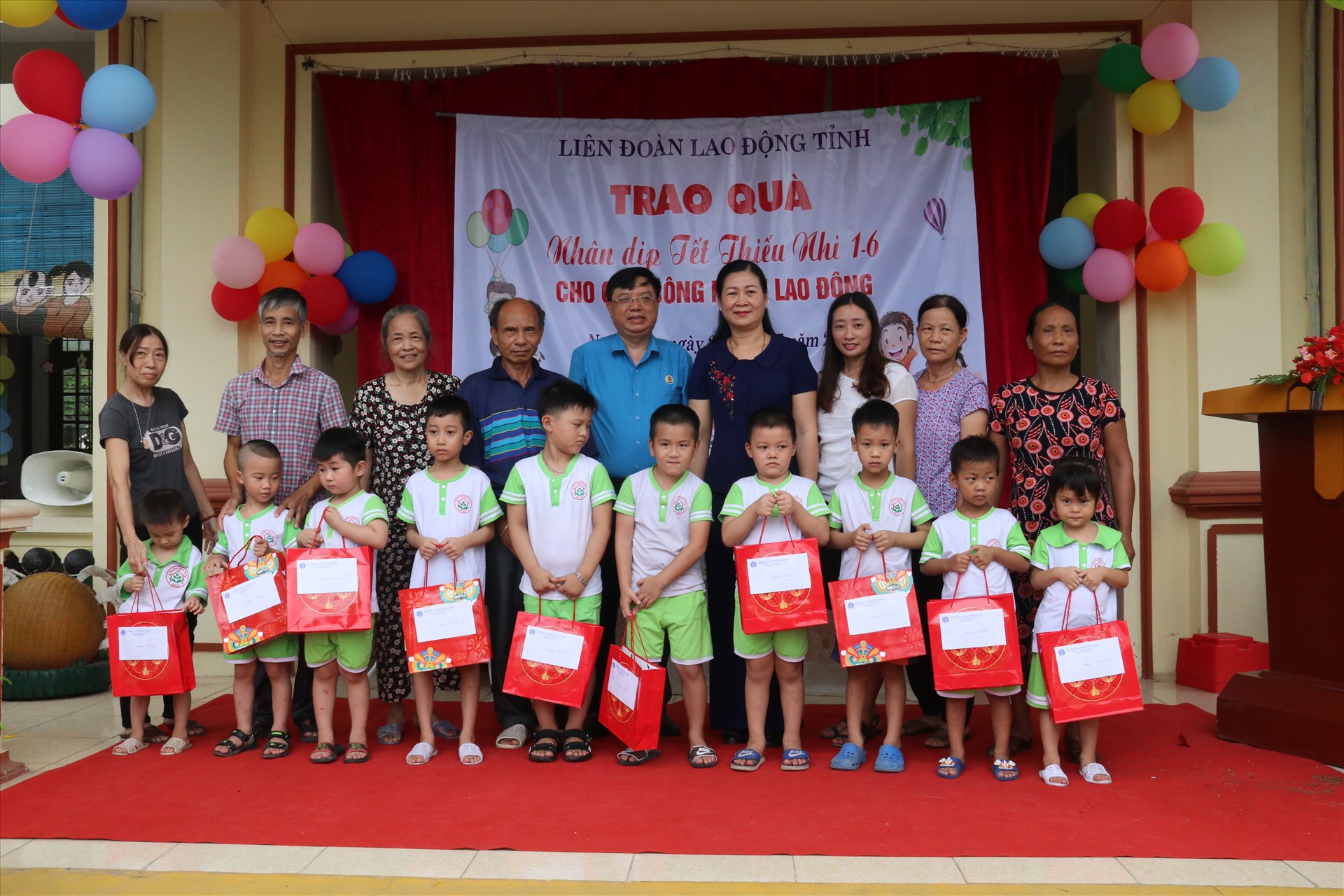 Các đồng chí lãnh đạo trao quà tới các em học sinh là con công nhân lao động. Ảnh: Hoàng Thọ Thanh Xuân.