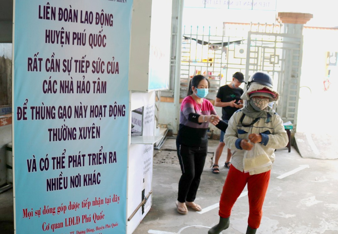 Người lao động khó khăn nhận gạo từ Thùng gạo thiện nguyện của LĐLĐ Phú Quốc. Ảnh: LT