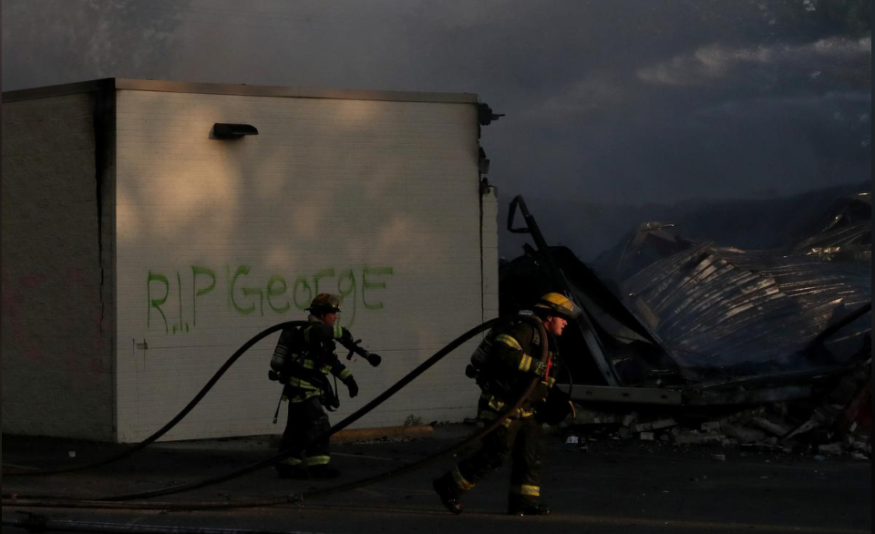 Lính cứu hỏa dập tắt đám cháy do người biểu tình gây ra tại Minneapolis, Minesota, Mỹ, ngày 30.5. Ảnh: RT
