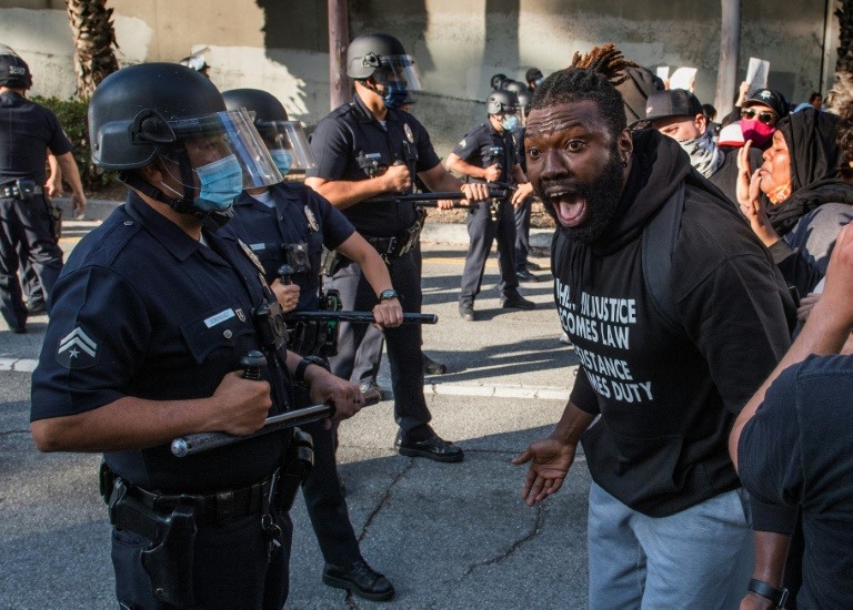 Một người biểu tình đối đầu với cảnh sát ở Los Angeles. Ảnh: AFP