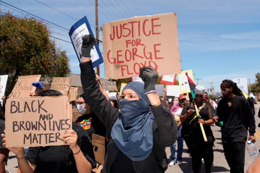 Người biểu tình cầm biểu ngữ diễu hành về phía cảnh sát tại Los Angeles, California, Mỹ, ngày 30.5. Ảnh: RT