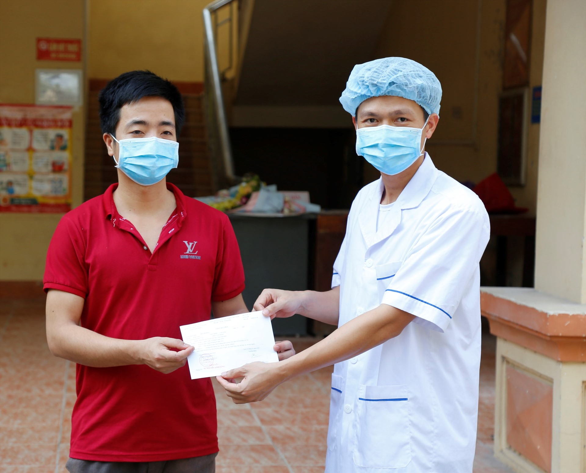 Đại diện lãnh đạo Bệnh viện Đa khoa huyện Kim Sơn trao giấy ra viên cho bệnh nhân 170. Ảnh: NT