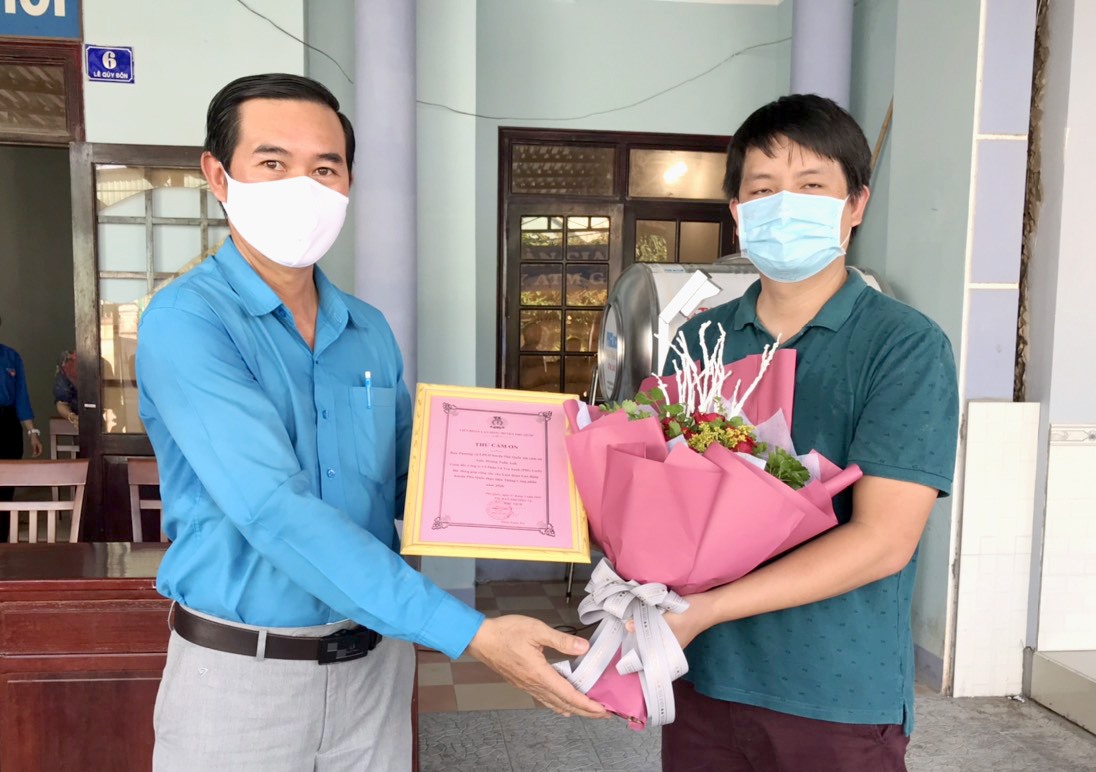 Chủ tịch LĐLĐ Phú Quốc Phan Xuân Trí trao Thư cảm tạ và hoa cho nhà hảo tâm. Ảnh: LT