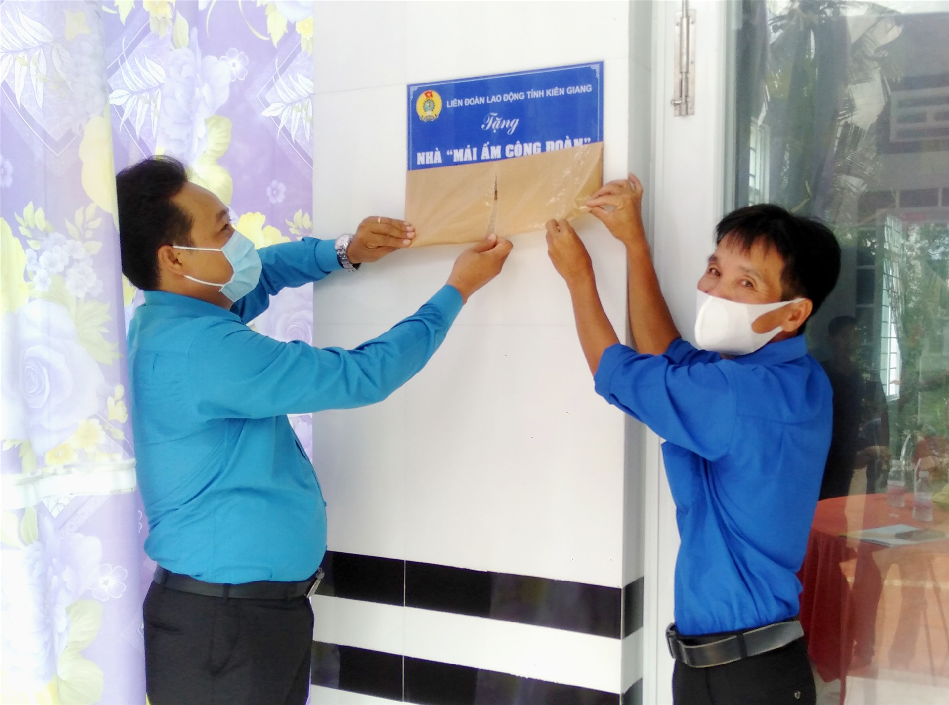 Ông Phạm Văn Đằng và đoàn viên Trần Quang Vinh thực hiện nghi thức khánh thành căn nhà. Ảnh: LT