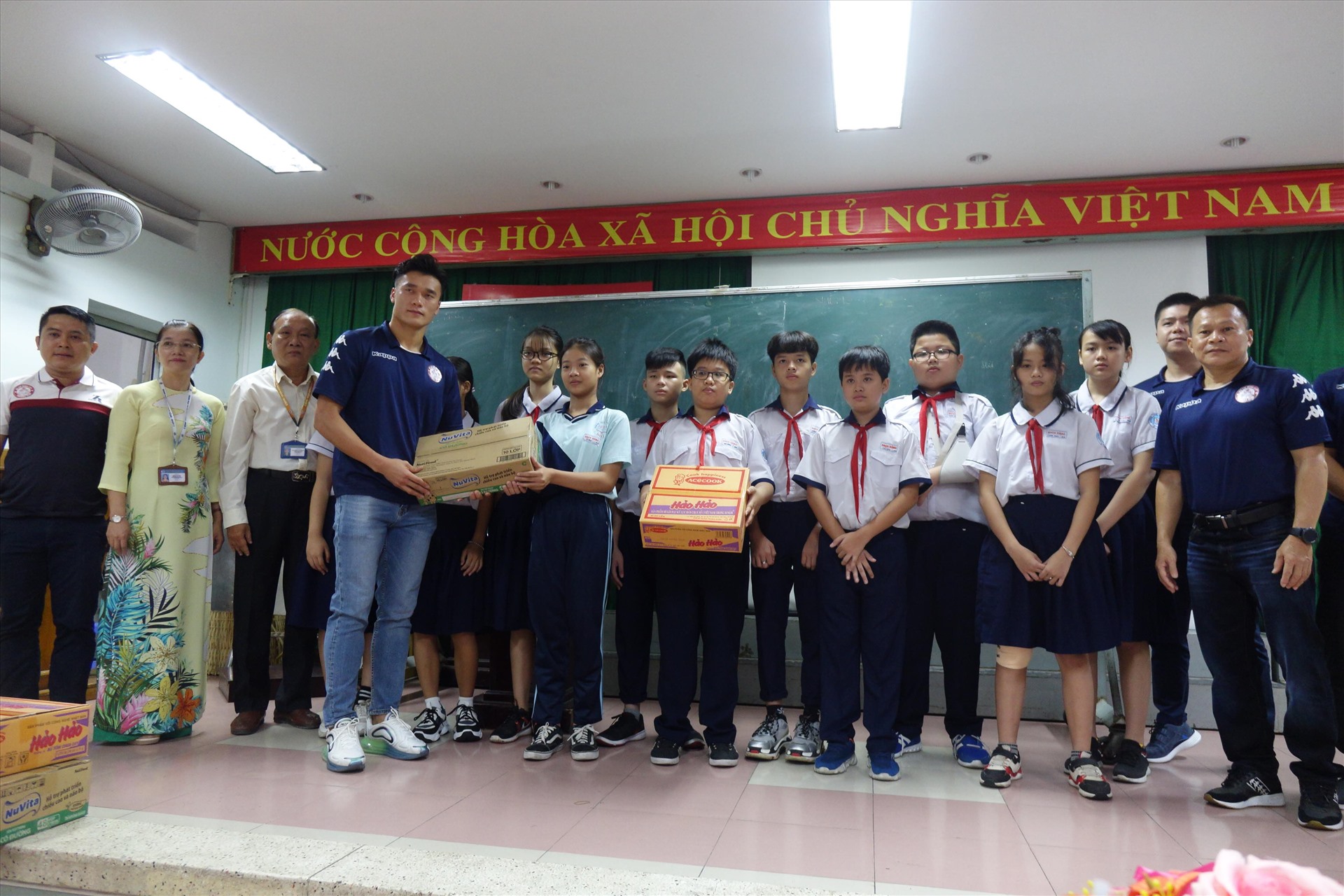 Bùi Tiến Dũng cùng đội TP.HCM tặng quà cho các em học sinh trường THCS Bạch Đằng. Ảnh: Nguyễn Đăng.