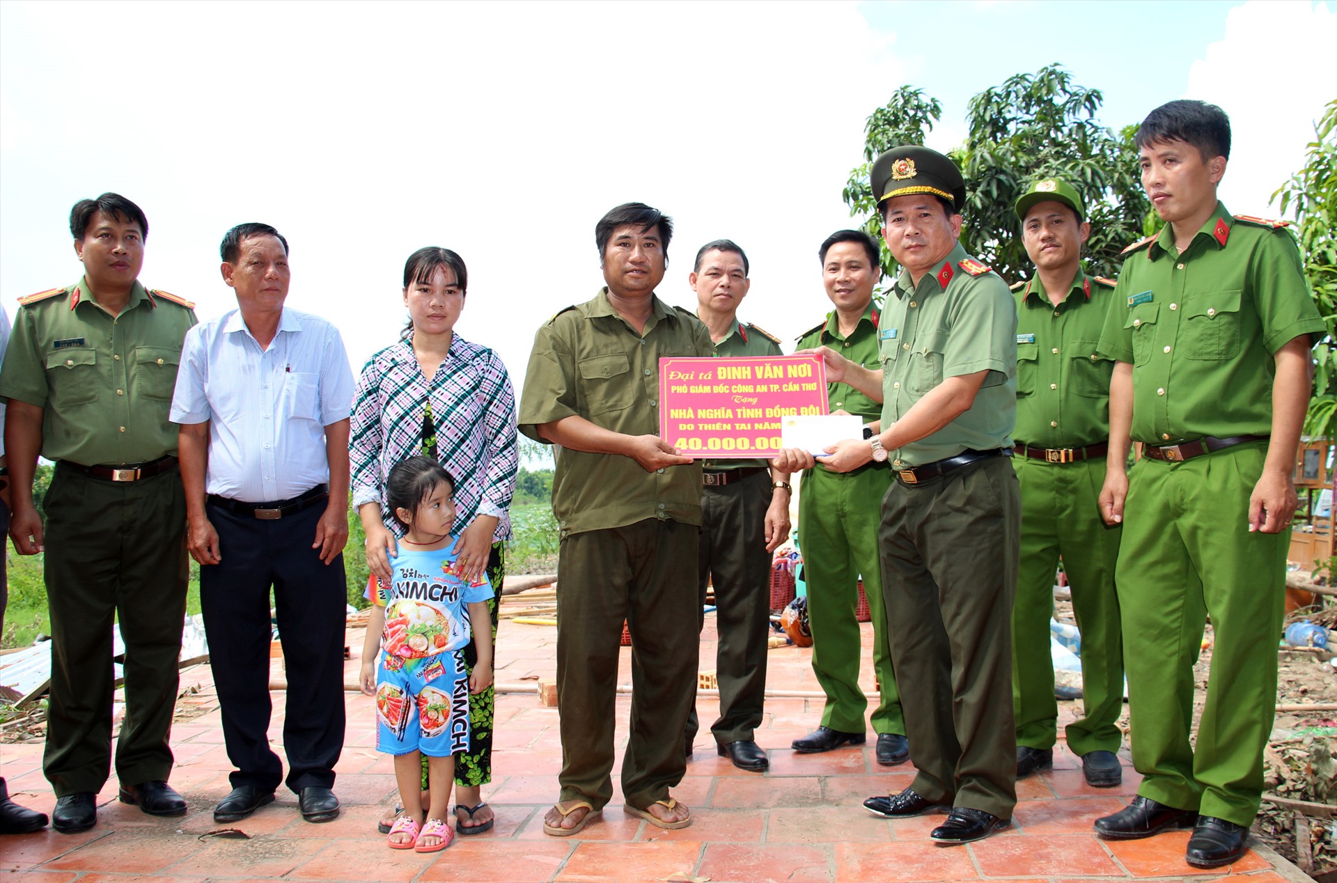 Đại tá Đinh Văn Nơi trao tặng số tiền 40 triệu đồng cho gia đình có nhà bị sập bởi giông lốc. Ảnh: Tr.L.