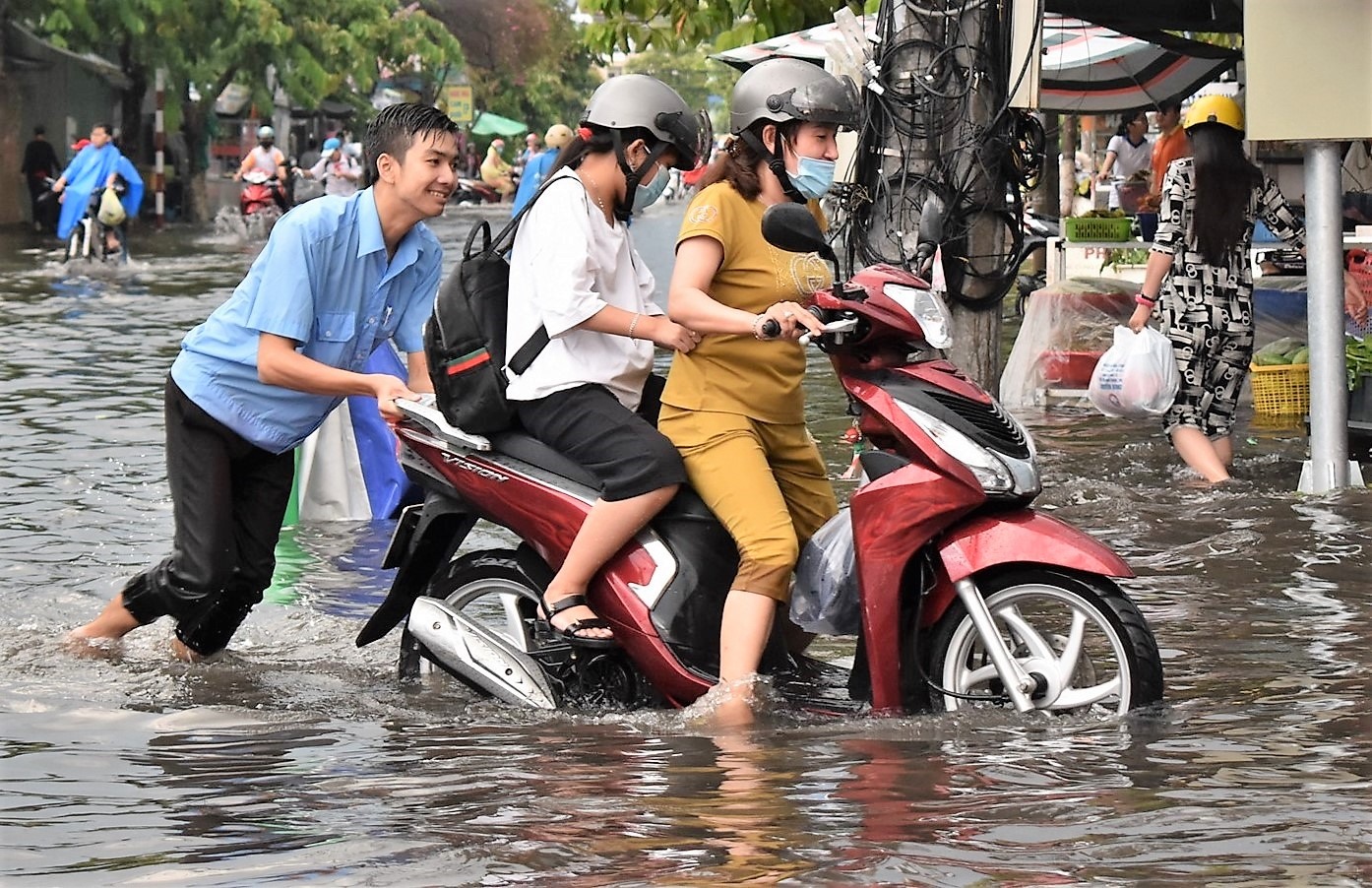 Sinh viên lội nước ngập giúp người đi đường sau trận mưa lớn