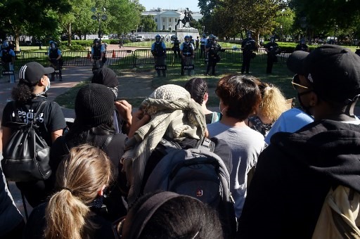 Cách sĩ quan cảnh sát tạo thành một vành đai bảo vệ xung quanh Nhà Trắng trước đám đông người biểu tình tập trung xung quanh, ngày 1.6. Ảnh: AFP
