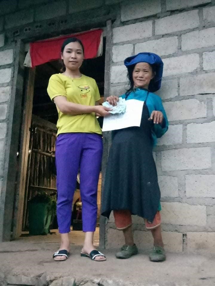 Chị Nguyễn Thị Thơ - đại diện nhóm từ thiện trao số tiền hỗ trợ tới cụ Vàng Thị Xá